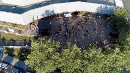 Besucher der Kulturterrasse der Stadthalle blicken auf die Bühne während einer Live-Veranstaltung.