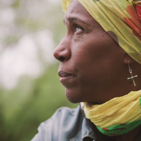 Felicia blickt nachdenklich in den Himmel und erinnert sich an die Herausforderungen ihres Lebens. 