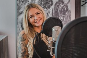 Mitarbeiterin der Tourist-Information Fürth sitzt am Tisch und nimmt eine neue Podcastfolge auf