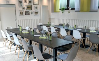 Mehrere zusammengestellte Tische im Frankies Hofladen mit Gläsern, Blumendeko und Wandbildern