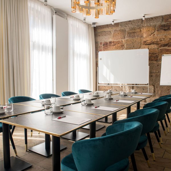 Heller Tagungsraum Freiraum im Werners Boutique Hotel Fürth mit Sandsteinwand, Tischen, Stühlen und Flipchart