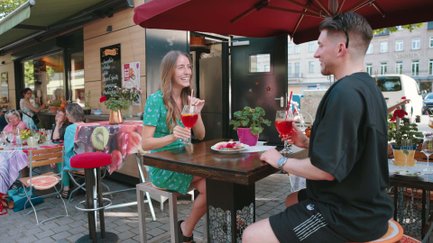 Pärchen trinkt Spritz neben Marktstand auf dem Fürther Markt in Fürth bei sommerlichem Wetter