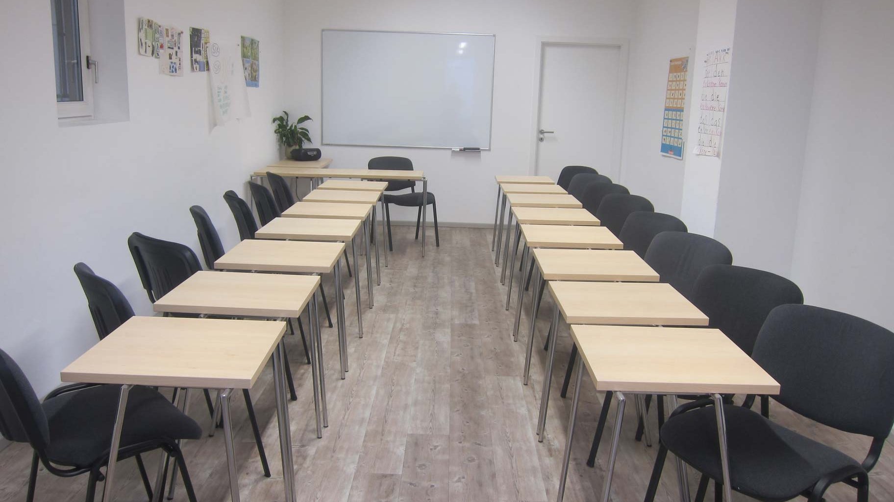 Kleiner Tagungsraum in der Matilde Fürth mit Whiteboard, Tischen und Stühlen für Meetings.