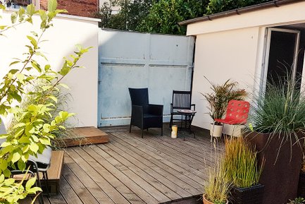 Kleiner Außenbereich der Matilde Fürth mit Stühlen, Pflanzen und Holzboden für entspannte Pausen