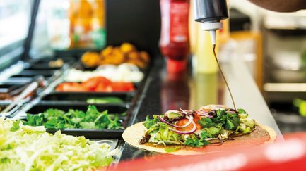 Zubereitung von Chee-Köfte-Wraps auf dem Fürther Markt in Fürth mit Salat, Zwiebeln und Tomaten