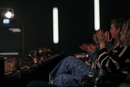 Nahaufnahme von Personen, die in einem vollbesetzten Kinosaal im Cineplex Fürth bei Veranstaltung applaudieren