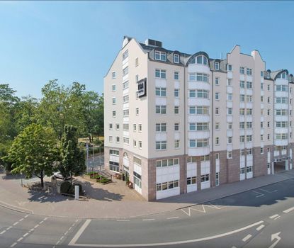 Hotel nh Fürth außen Blick auf die Außenfasade des Hotel Fürth Nürnberg. Links daneben sind die Bäume der Konrad-Adenauer-Analge zu sehen.