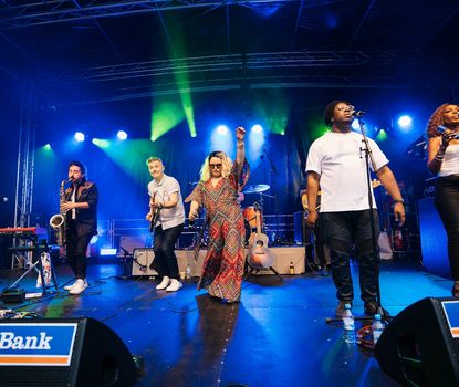 New_Orleans_Festival_26 Sänger und Band performen auf der Bühne vor Publikum.