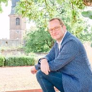 Volker Heißmann Der Komödiant, Schauspieler und Sänger Volker Heißmann sitzend in einem Park.