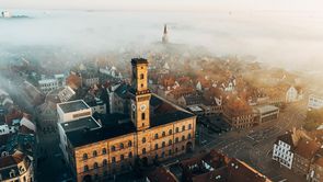 Blickpunkt Rathaus, Turm & Co. Die Altstadt von oben mit Aussicht des Rathauses und der Kirche St. Michael, bei einem nebligen Morgen
