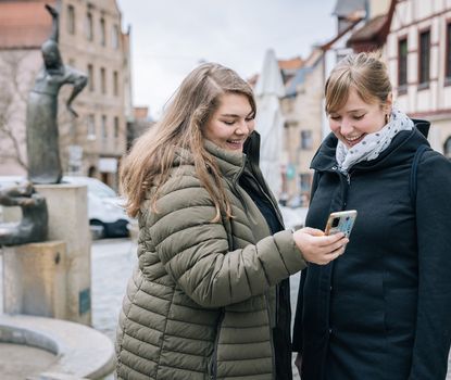 Zwei Frauen am Grünen Markt in Fürth lösen ein Rätsel bei der Schnitzeljagd-App