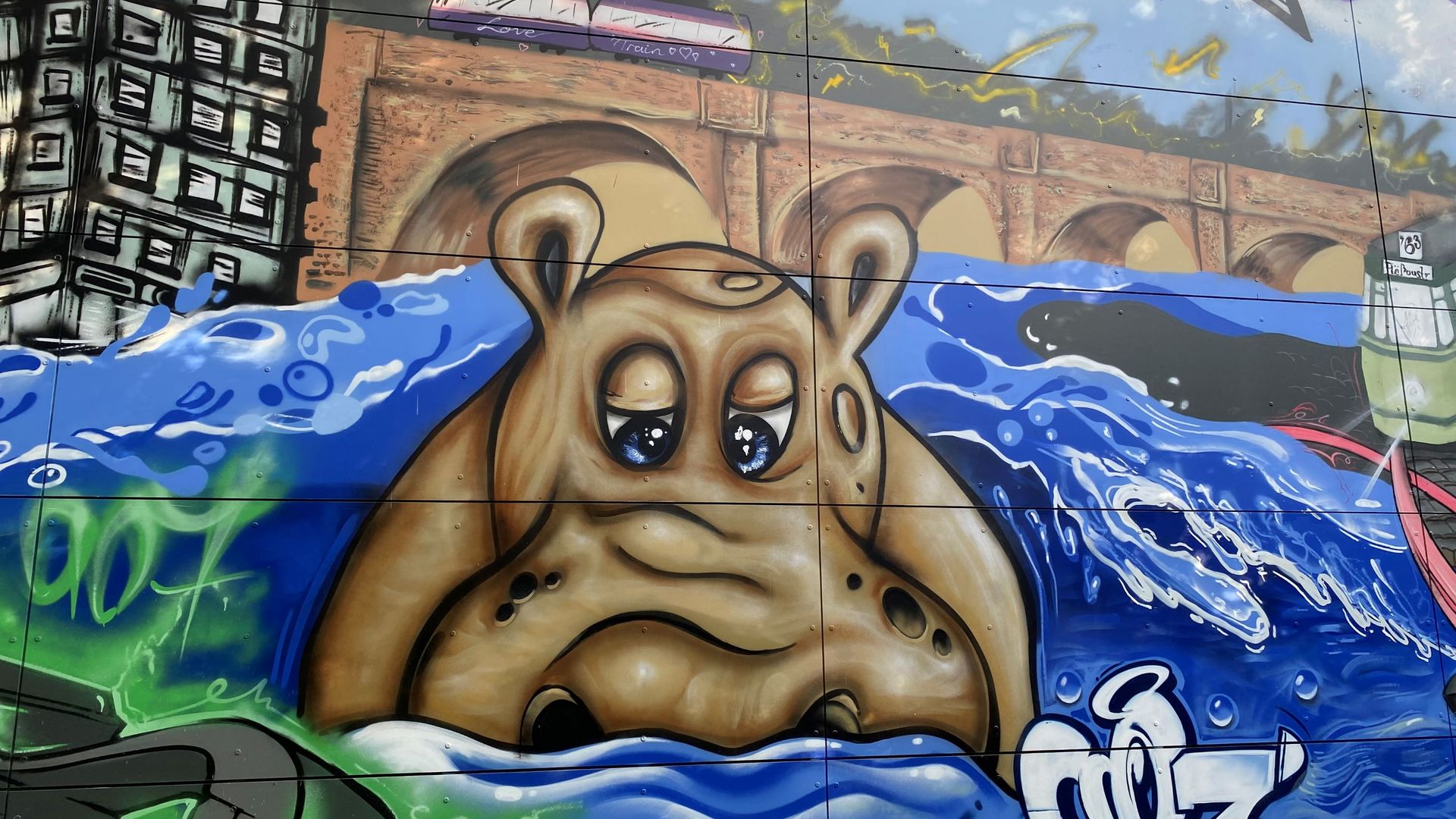 Im Vordergrund ist auf dem Wandbild an der neuen Feuerwache das Nilpferd Elsbeth zu sehen. Im Hintergrund ist die Siebenbogenbrücke und die Regnitz zu sehen.