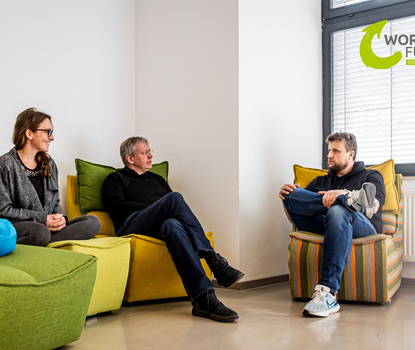 Workin 1 Eine Frau und zwei Männer arbeiten in Coworkingspaces und tauschen sich aus, bzw. besprechen sich.