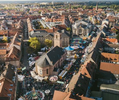 Blick auf die Michaelis-Kirchweih Stände und Fahrgeschäfte entlang der Königstraße während der Michaelis-Kirchweih. Im Vordergrund die Kirche