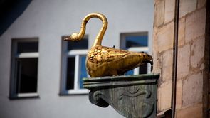 Goldener Schwan Goldene Statue eines Schwans auf einem Sockel am Eck des ehemaligen Gasthauses