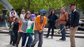 Fürth für Familien Links eine Gruppe von Kindern, die eine Polonese bilden. Rechts im Bild der Stadtführer als Ordnungshüter mit Mütze