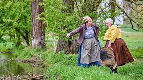 A su a Gwaaf - Zwei Fischweiber erzählen Zwei Fischweiber diskutieren am Flussufer der Rednitz an einem Sommertag. Die Natur und Pflanzen sind saftig grün.