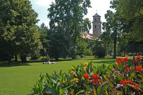 Stadtpark Fürth Blick auf den Turm der Auferstehungskirche im Stadtpark Fürth.Zu Sehen sind rote Blumen, Wiese und einige grüne Bäume.